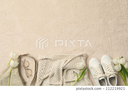 Spring light female outfit and flowers on beige background, space for text Spring light female outfit and flowers on beige background, space for text 112219921