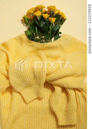 Flowers in yellow sweater on light background, top view Flowers in yellow sweater on light background, top view 112219938