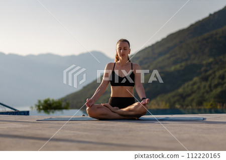 Morning outdoor meditation in mountain resort near the pool 112220165
