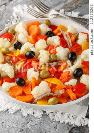 Insalata Di Rinforzo Italian cauliflower salad with giardiniera, olives and anchovies closeup on the plate. Vertical 112220268