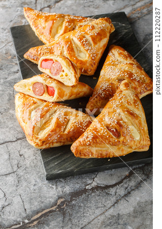 Sausage And Puff Pastry Turnovers closeup on the marble board. Vertical Sausage And Puff Pastry Turnovers closeup on the marble board. Vertical 112220287