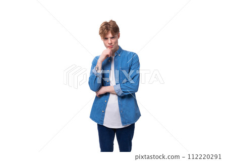 young handsome red-haired guy dressed in a blue shirt on a white background with copy space young handsome red-haired guy dressed in a blue shirt on a white background with copy space 112220291