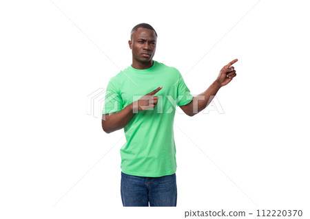 american brunette man with short haircut dressed in a light green t-shirt points his hand to the 112220370