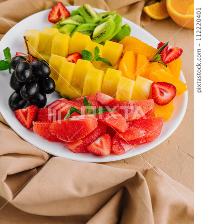 assorted sliced tropical fruits on plate 112220401