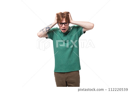 young european guy with red hair is shocked and puzzled on a white background with copy space young european guy with red hair is shocked and puzzled on a white background with copy space 112220539