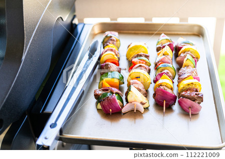 Flavorful beef and colorful veggie skewers, marinated and grilled to perfection, sizzling on a baking sheet. Flavorful beef and colorful veggie skewers, marinated and grilled to perfection, sizzling on a baking sheet. 112221009