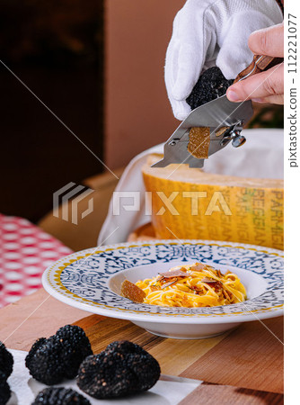 Chef Grating Truffle Shavings on Pasta with Parmesan Chef Grating Truffle Shavings on Pasta with Parmesan 112221077