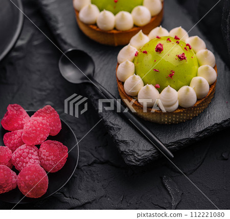 Slice of matcha cake with vanilla and raspberries 112221080
