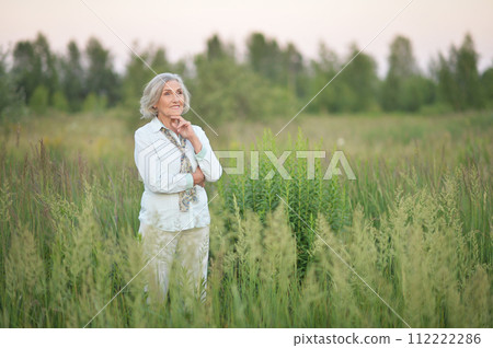 Portrait of happy senior woman posing in spring park 112222286