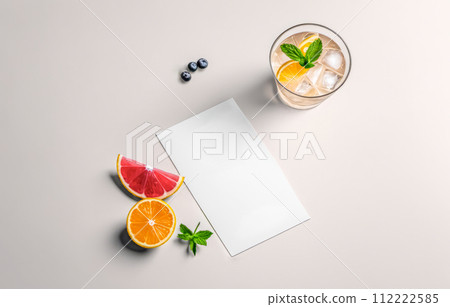 Top view of an elegant cocktail with ice and mint. white blank card is adjacent, ideal for bar menus or recipes. Citrus slices of orange, lime, and grapefruit offer colorful contrast Top view of an elegant cocktail with ice and mint. white blank card is adjacent, ideal for bar menus or recipes. Citrus slices of orange, lime, and grapefruit offer colorful contrast 112222585
