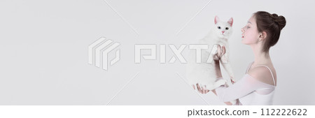 Marketing materials for veterinary clinic that specializes in cats. Tender young girl posing with adorable white cat against white studio background 112222622