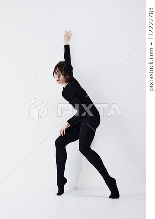 Full-length image of passionate, artistic young woman with smoky eyes makeup, black clothes standing in dynamic pose against white studio background 112222783