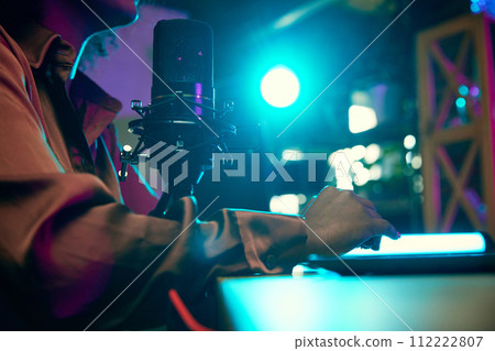Focus on female hands, microphone and laptop. Blogger making online podcast show, discussing interesting topics Focus on female hands, microphone and laptop. Blogger making online podcast show, discussing interesting topics 112222807