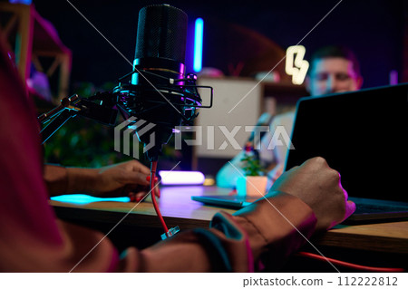 Focus on female hands, microphone and laptop. Blogger making online podcast show, discussing interesting lifestyle topics Focus on female hands, microphone and laptop. Blogger making online podcast show, discussing interesting lifestyle topics 112222812