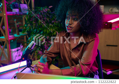 Young African woman, blogger taking part in online podcast show, giving interview, discussing interesting lifestyle topics 112222822
