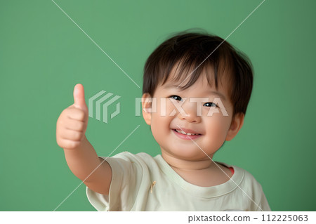 Cheerful  Toddler Giving Thumbs Up on Solid colored Background 112225063