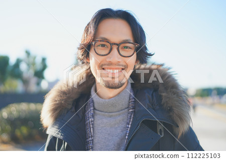 一個穿著外套的男人在冬日陽光明媚的夜晚行走 112225103