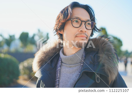 一個穿著外套的男人在冬日陽光明媚的夜晚行走 一個穿著外套的男人在冬日陽光明媚的夜晚行走 112225107