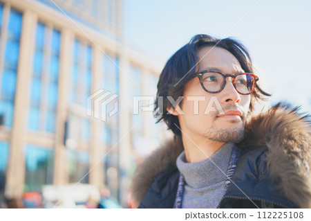 一個穿著外套的男人在冬日陽光明媚的夜晚行走 一個穿著外套的男人在冬日陽光明媚的夜晚行走 112225108
