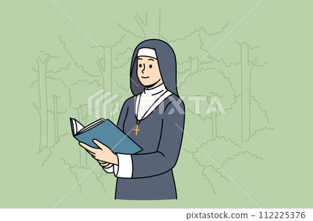Woman nun with holy book stands in park, dressed in cassock for religious service in temple Woman nun with holy book stands in park, dressed in cassock for religious service in temple 112225376