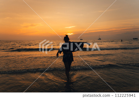 Summer sunset,Woman walking on the beach watching the sunset Summer sunset,Woman walking on the beach watching the sunset 112225941