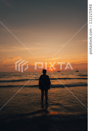 Summer sunset,Woman walking on the beach watching the sunset Summer sunset,Woman walking on the beach watching the sunset 112225948