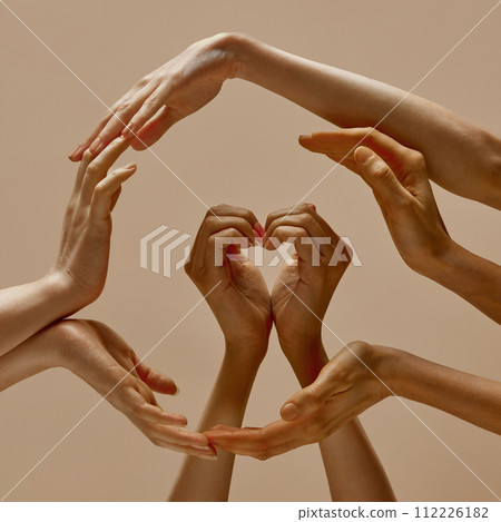 Photo of human hands making circle symbol and shape of heart of unity, support and care against sandy color studio background. Photo of human hands making circle symbol and shape of heart of unity, support and care against sandy color studio background. 112226182