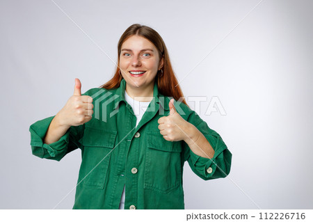 Young 30s caucasian woman isolated on white background giving a thumbs up gesture, studio portrait. Young 30s caucasian woman isolated on white background giving a thumbs up gesture, studio portrait. 112226716