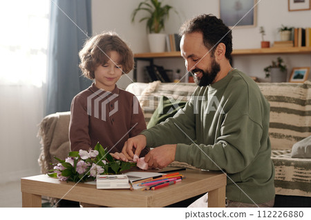 Helping his father tie bunch of flowers Helping his father tie bunch of flowers 112226880