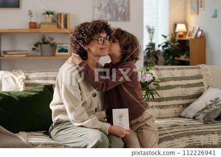 Boy embracing and kissing his mother Boy embracing and kissing his mother 112226941
