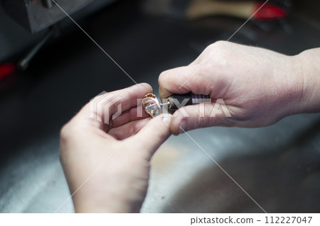 Industrial manufacture of the gold ring.Jeweler working on golden ring 112227047