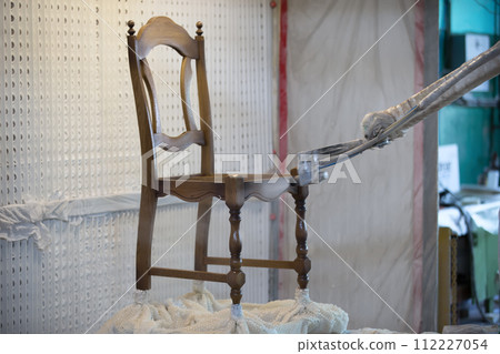 Covering the chair with lacquer.Painting chairs in the factory 112227054