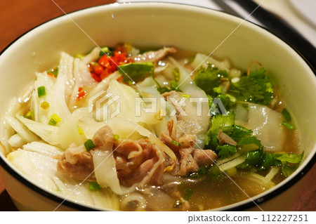 A close-up of a Vietnamese pho soup with chopsticks. 112227251