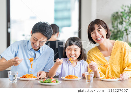 A family having lunch at a restaurant. 112227697