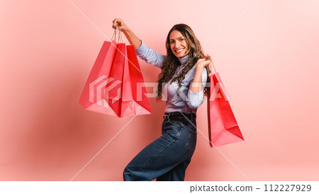 Happy hispanic woman with pink shopping bags 112227929