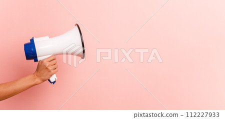 Unrecognizable person with megaphone in pink background 112227933