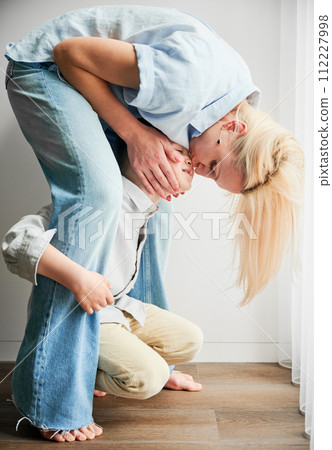 Lovely moment of mom kissing her son's nose. Little son playing with his mother. Cute portrait of female fooling around with her kid. 112227998