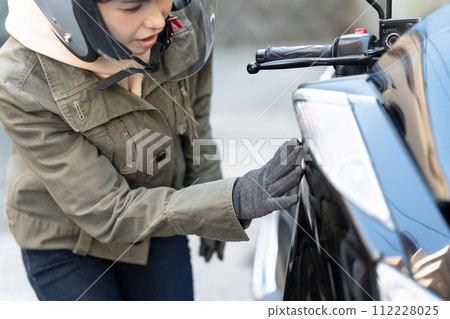 檢查摩托車的婦女 檢查摩托車的婦女 112228025