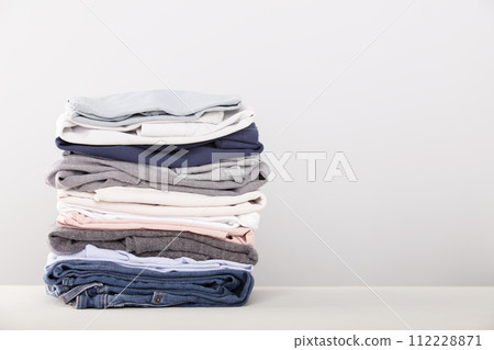 stack of folded clothes, grey background 112228871