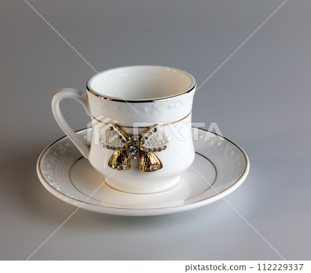 Empty antique porcelain coffee cup with bow on white background. 112229337