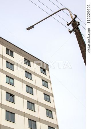 Windows of multi-storey tall building against background of sky Windows of multi-storey tall building against background of sky 112229601
