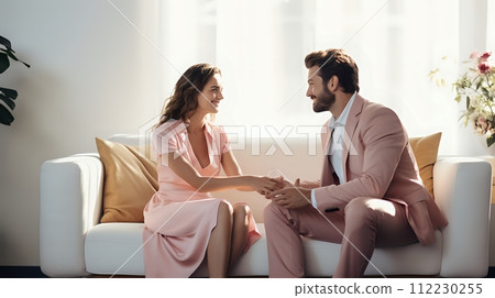 A man and a woman, both dressed in pink, are sitting on a white 112230255