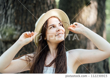 Woman Enjoying Nature with Summer Hat and Wildflowers Woman Enjoying Nature with Summer Hat and Wildflowers 112230915
