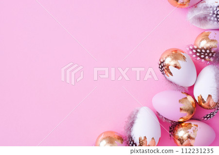 Easter eggs with golden glitter on pink background with copy space 112231235