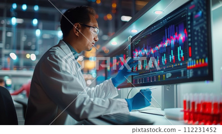 Woman in Lab Coat and Goggles Looking at Screen 112231452