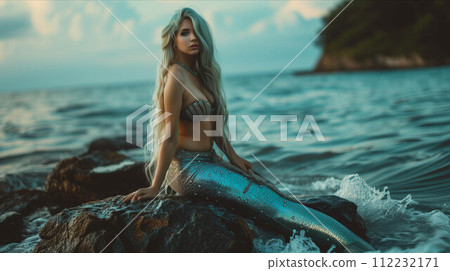 Young mermaid sitting on a rock on an island in the sea. Young mermaid sitting on a rock on an island in the sea. 112232171