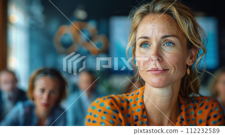Woman With Blue Eyes Sitting in Front of Group of People Woman With Blue Eyes Sitting in Front of Group of People 112232589