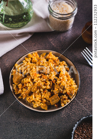 Traditional spicy pilaf with rice and meat on a plate on the table vertical view 112232933