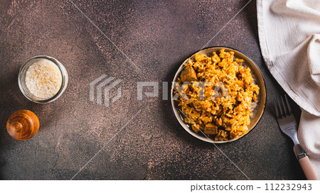 Traditional spicy pilaf with rice and meat on a plate on the table top view web banner 112232943