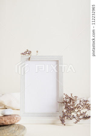 Empty photo frame, dried flowers and stones on a light background vertical view Empty photo frame, dried flowers and stones on a light background vertical view 112232965
